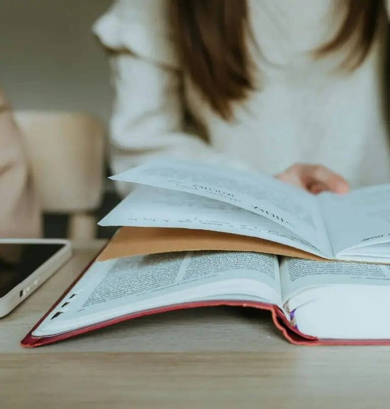 how to read the Bible millennial girl reading bible with guide with phone next to bible