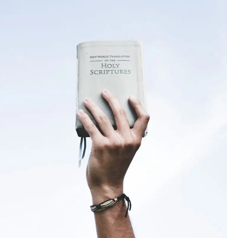 young man holding bible in air