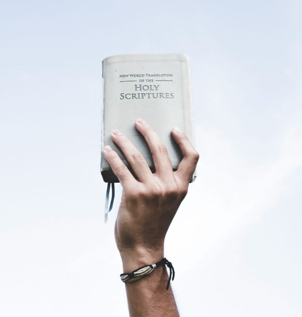 young man holding bible in air