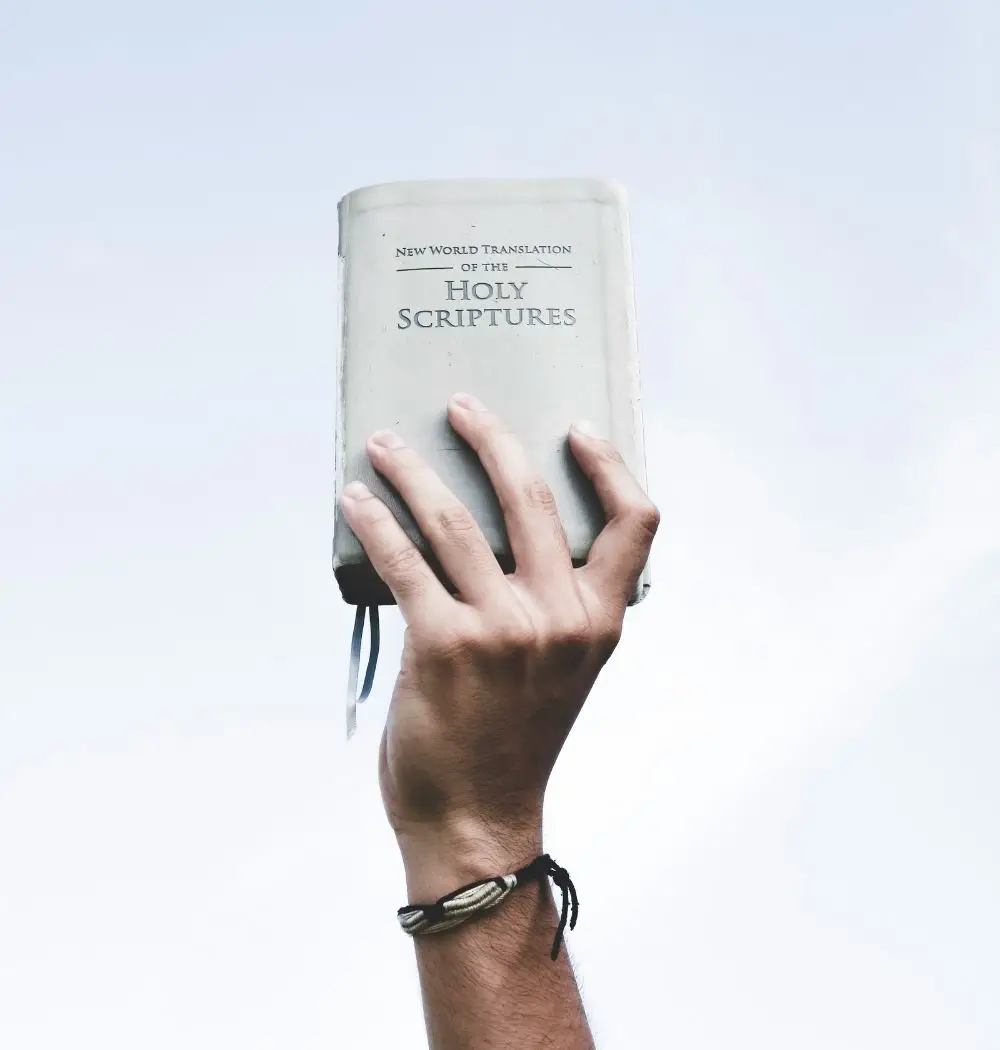 young man holding bible in air