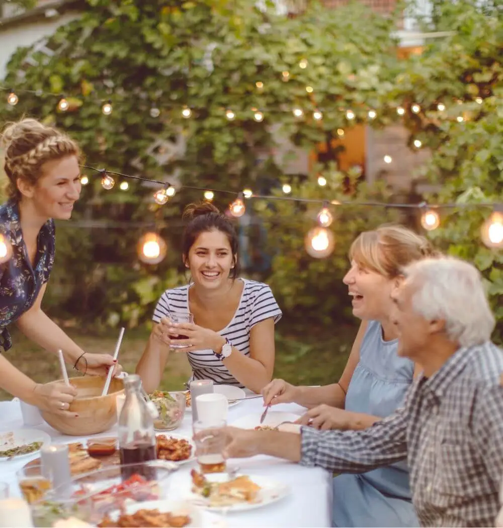 Intergenerational family talking and laughing at outdoor dinner table