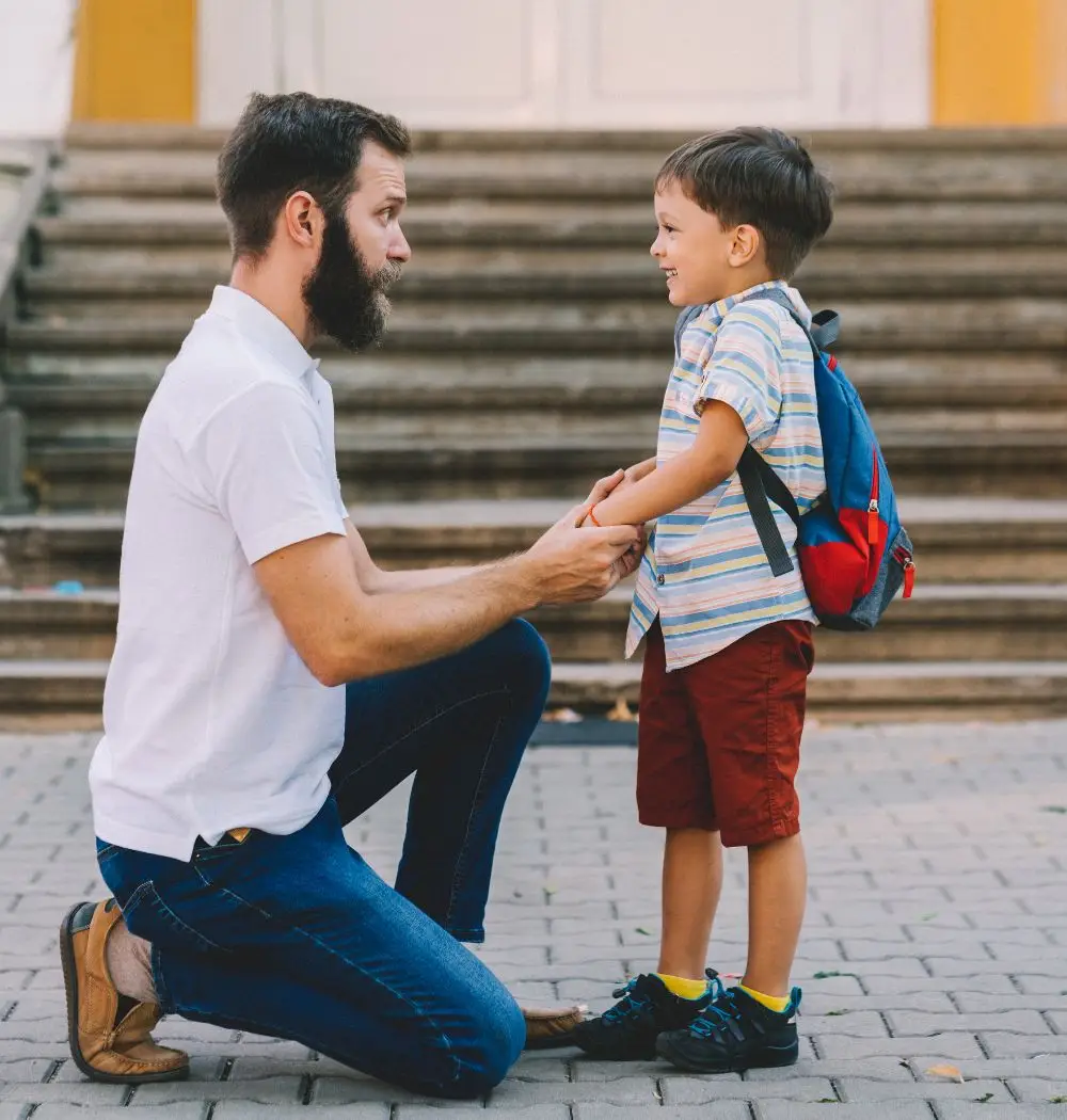 dad parents young son outside of school steps